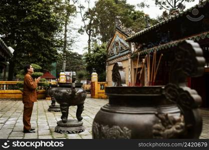 side view man praying temple with incense
