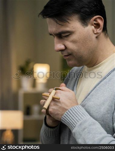 side view man praying with wooden cross