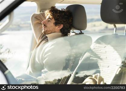 side view man relaxing car while road trip