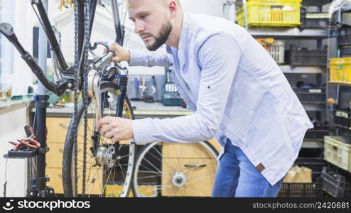 side view man repairing bicycle