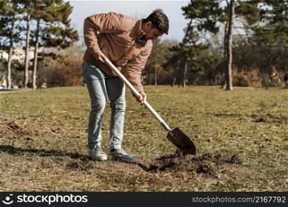 side view man using shovel dig hole planting tree
