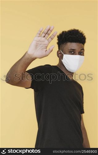 side view man with face mask lifting hand up