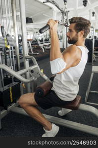 side view man with medical mask his forearm working out gym