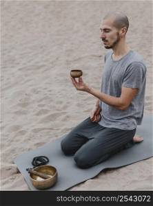 side view man with singing bowl outdoors