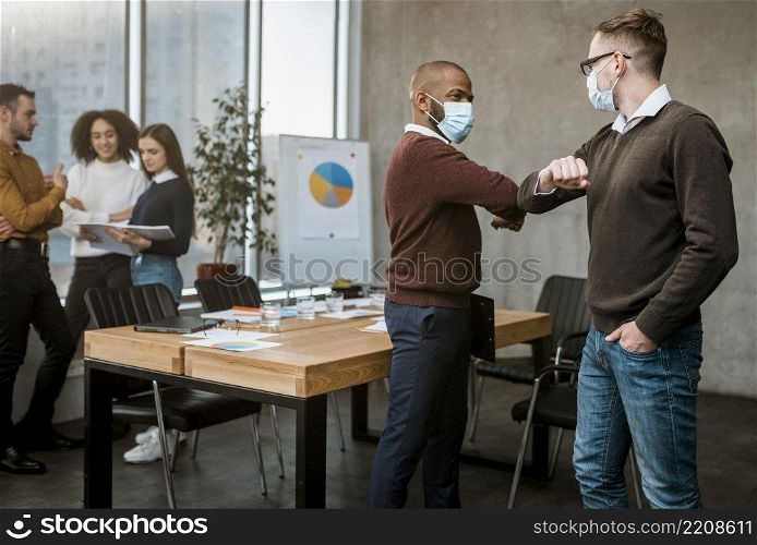 side view men elbow saluting each other during meeting