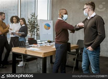 side view men elbow saluting each other during meeting