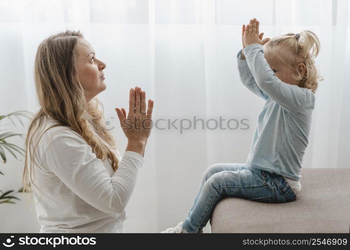 side view mother praying with her child