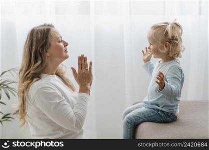 side view mother praying with her child home