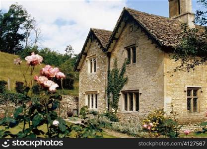 Side view of a cottage with a garden in its front, Castle Combe, England