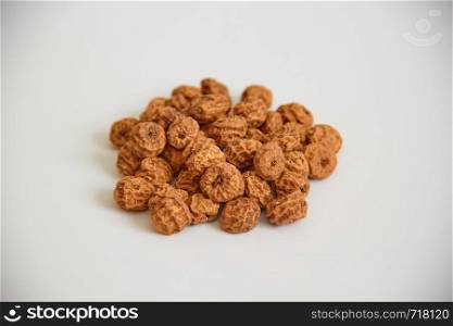 Side view of a pile of insulated tigernuts on a white background. The Spanish tigernut is called chufa