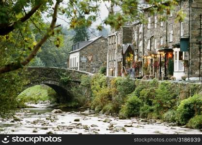 Side view of a stone bridge and shops in Beddgeurant, Wales