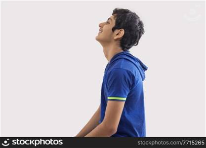 SIDE VIEW OF A TEENAGE BOY HAPPILY LOOKING ABOVE