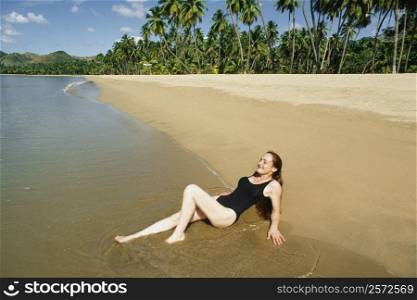 Side view of a woman relaxing on a beach, Mayaquez beach,San Juan, Puerto Rico