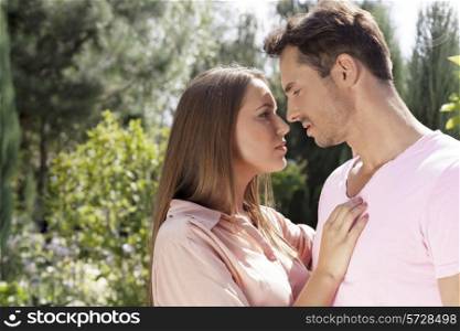 Side view of affectionate young couple looking at each other in park