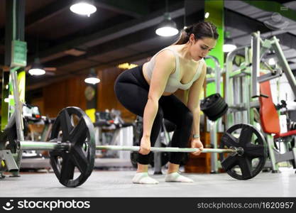 Side view of Athletic woman exercising deadlift in a gym. High quality photo. Side view of Athletic woman exercising deadlift in a gym.