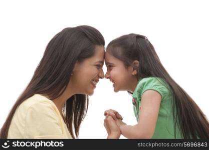 Side view of beautiful mother with her sweet little daughter over white background