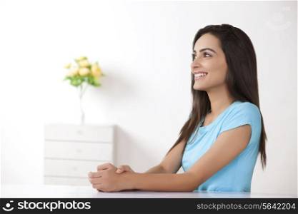 Side view of beautiful young woman smiling at home