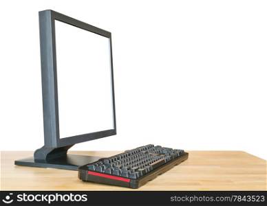 side view of black computer display with cut out screen and keyboard on wooden table isolated on white background