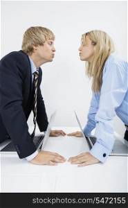 Side view of business couple kissing in office