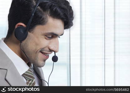 Side view of businessman wearing headset in office