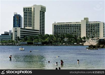 Side view of commercial buildings with a lake in the foreground, San Juan, Puerto Rico