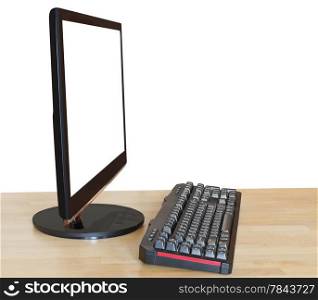 side view of computer black widescreen display with cutout screen and keyboard on wood table isolated on white background