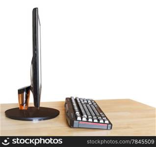side view of computer widescreen display with cutout screen and keyboard on wood table isolated on white background