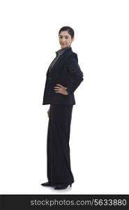 Side view of confident businesswoman with hand on hip isolated over white background