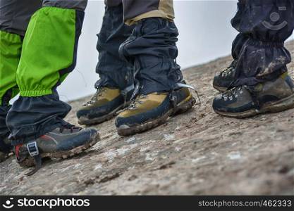 Side View of feet wearing hiking shoes with stone in background. Tourism concept. Selective focus.