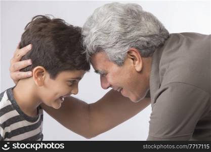 Side view of grandfather and grandson looking at each other