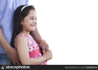 Side view of happy girl holding father&rsquo;s hand against white background