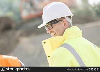 Side view of happy male supervisor at construction site