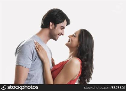 Side view of happy young couple against white background