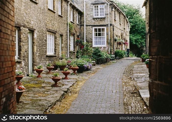 Side view of houses beside a cobblestone pavement, Burford, England