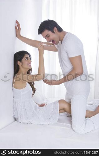 Side view of loving woman feeding man in bed