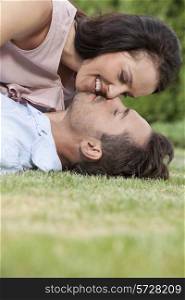 Side view of loving young couple about to kiss in park