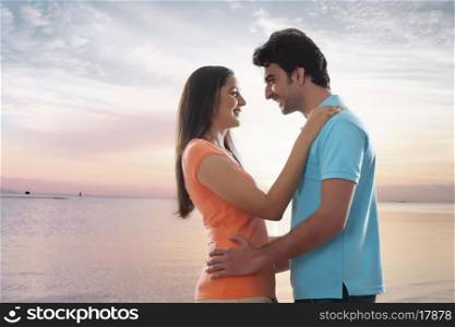 Side view of loving young couple embracing at beach