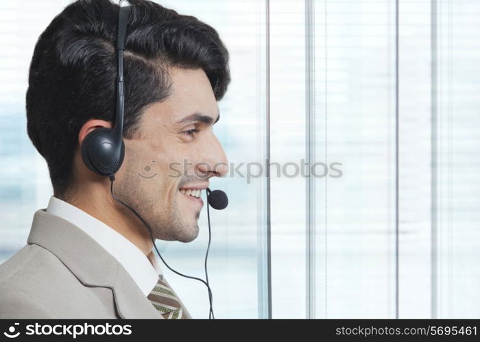 Side view of male customer service representative wearing headset in office