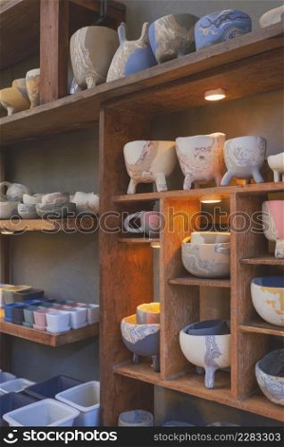 Side view of many various terracotta flower pots on wooden shelf decoration in vintage tone style and vertical frame