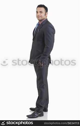 Side view of mid adult businessman with hand in pocket against white background