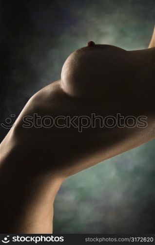 Side view of nude Caucasian female body arching backwards.