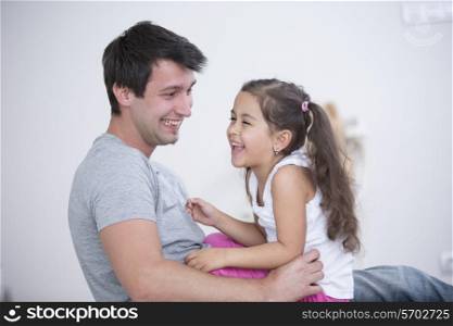 Side view of playful father and daughter at home