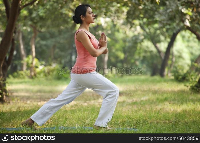Side view of pretty young woman practicing yoga