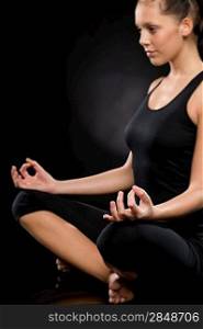 Side view of relaxed young woman exercising in lotus position