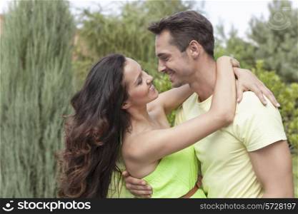 Side view of romantic young couple embracing in park