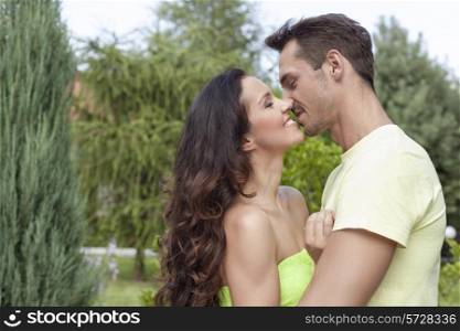 Side view of romantic young couple kissing in park