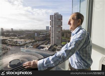 Side view of senior man standing on balcony