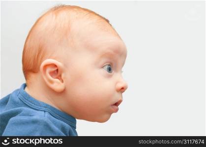 Side View of Sweet Curious Baby on Light Background