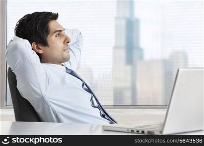 Side view of thoughtful businessman relaxing at his desk