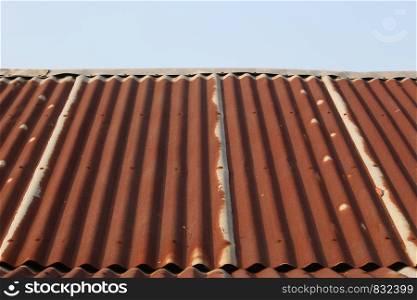 side view of very tin roof old with rusty and little blue sky at the top